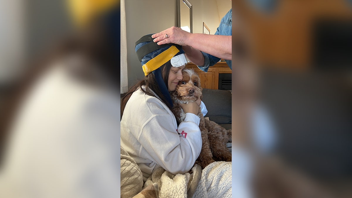 Mochi reconfortando a Breanna mientras hace una tapa para preservar el cabello durante la quimioterapia.